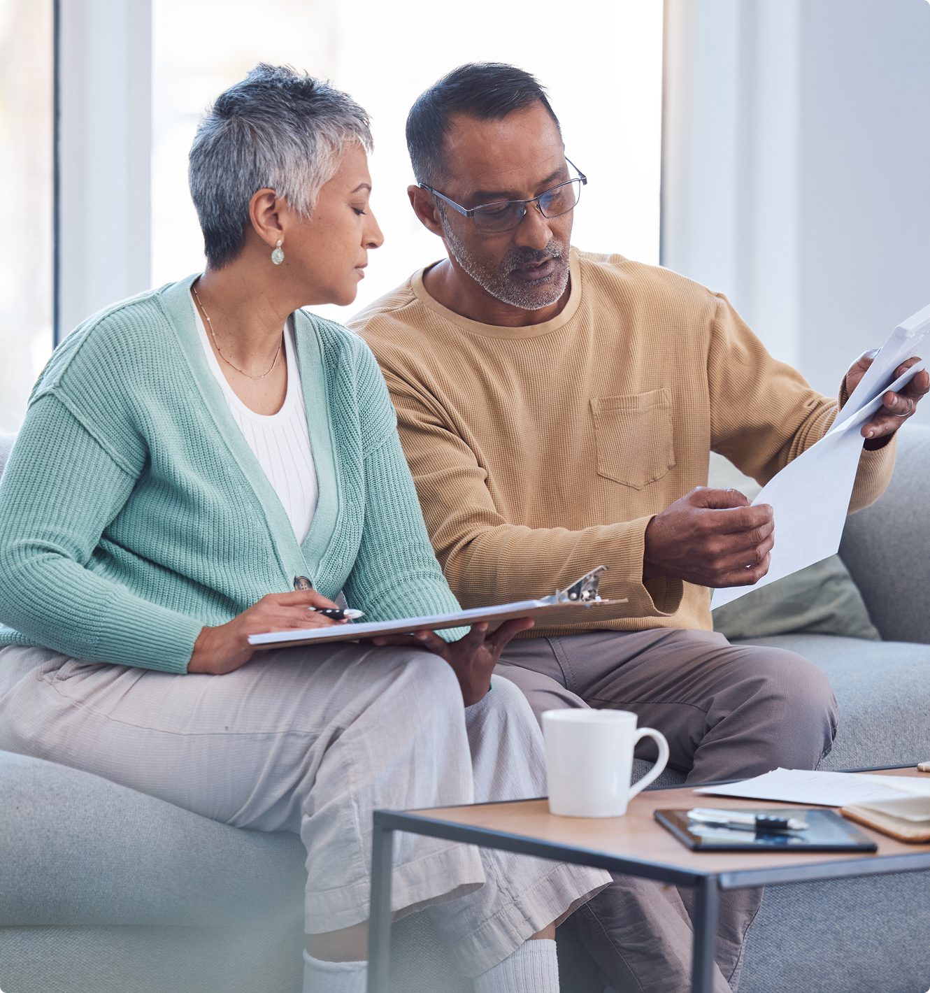 Older couple reviewing documents on couch.