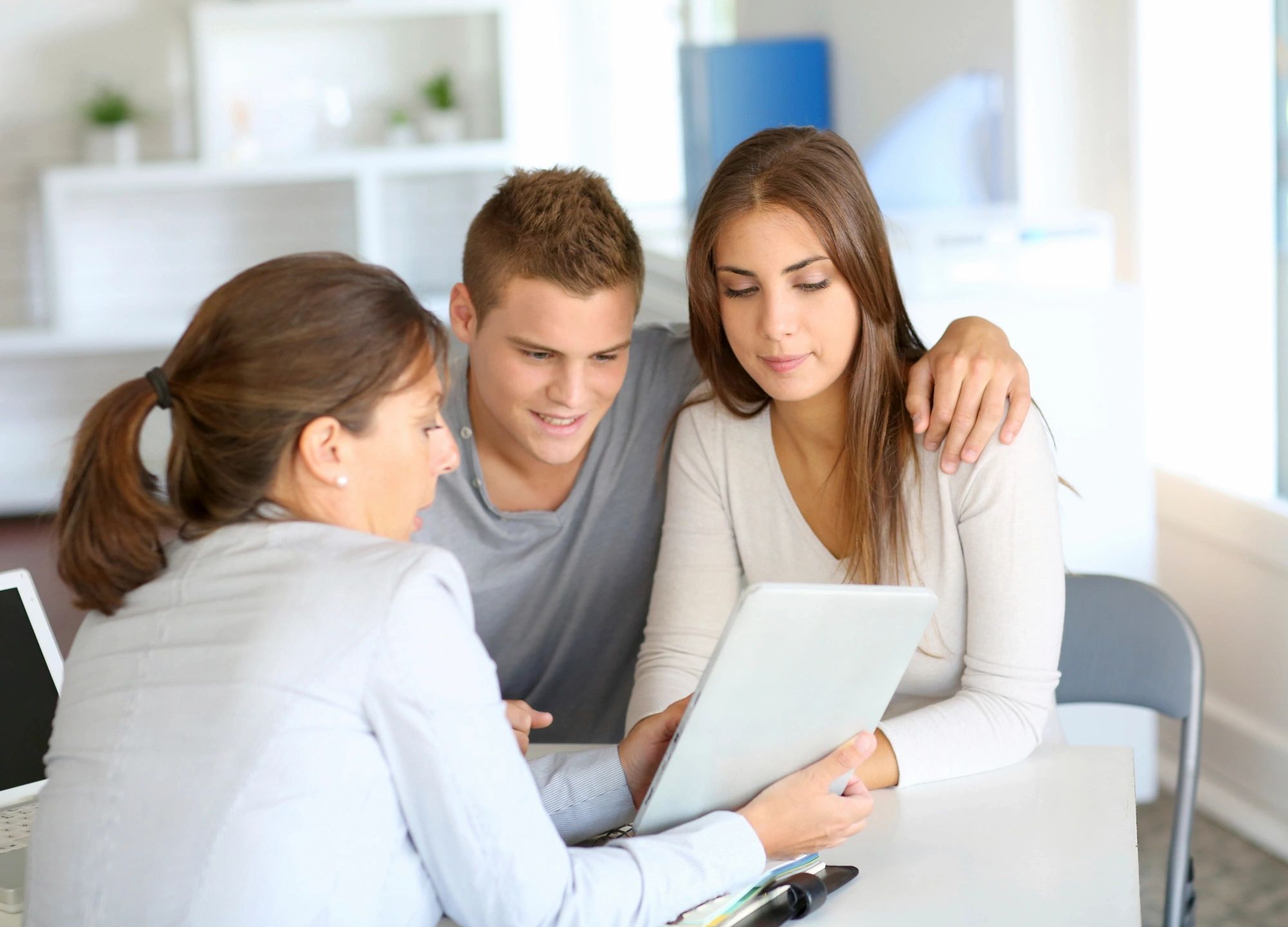 Couple consulting with a financial advisor using a tablet.