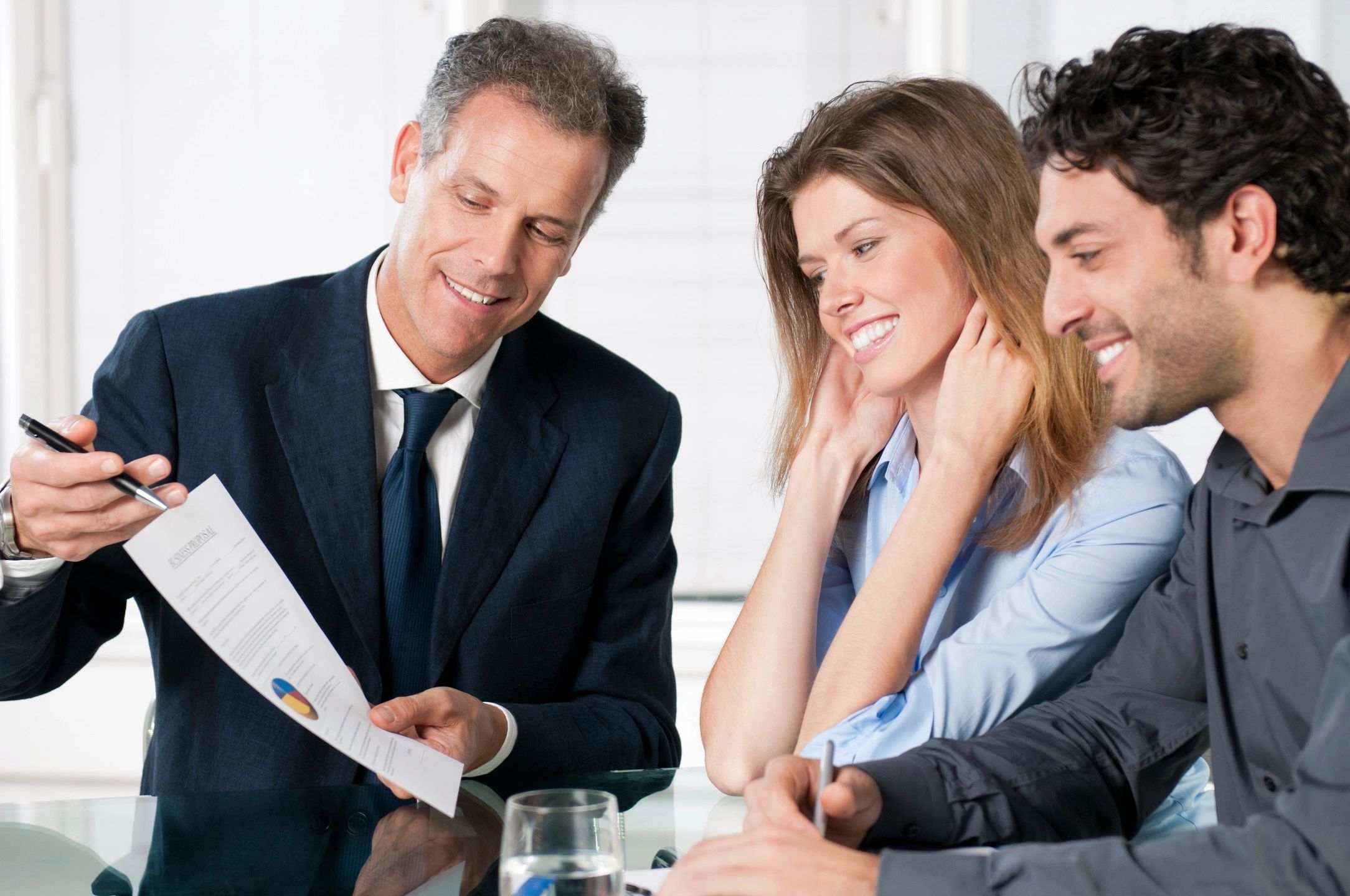 Businessman presenting a document to a couple in a meeting.