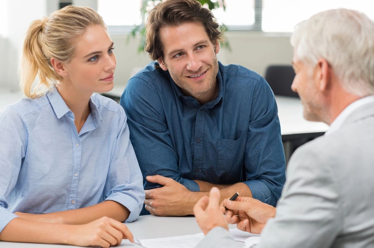 A couple consulting with a professional in an office setting.